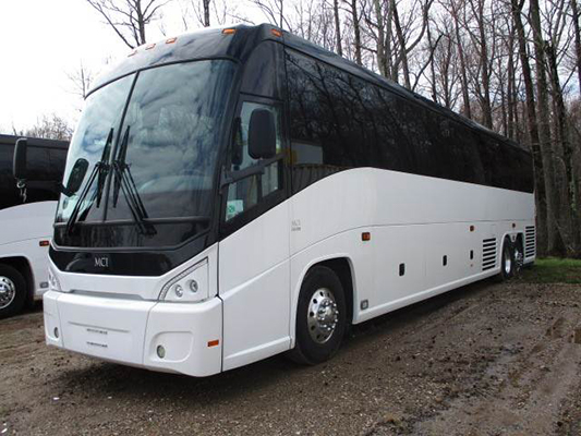 A charter bus parks in the woods